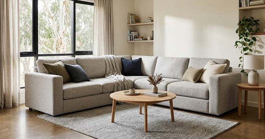 Contemporary grey three-seat sofa displayed in a furniture showroom, showcasing an affordable modern seating option.