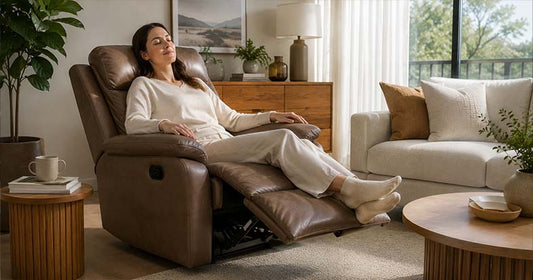 Woman relaxing on a leather recliner lounge chair with extended footrest in a modern living room