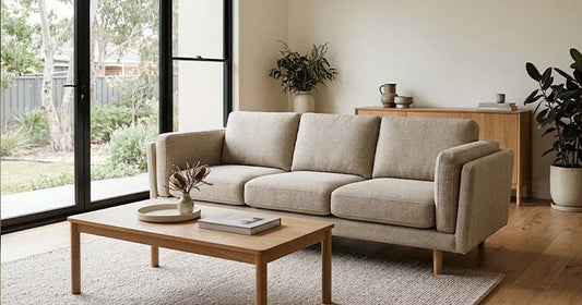 Beige three-seater sofa displayed in a modern Australian furniture showroom, illustrating Australian-made sofa quality and pricing.