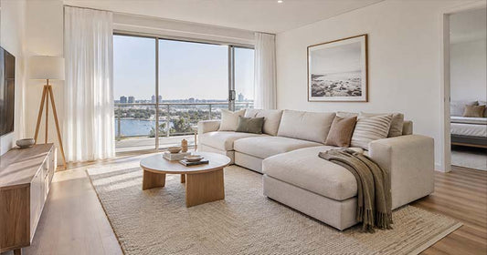 Spacious modern living room with a large fabric sectional lounge, coffee table and neutral rug