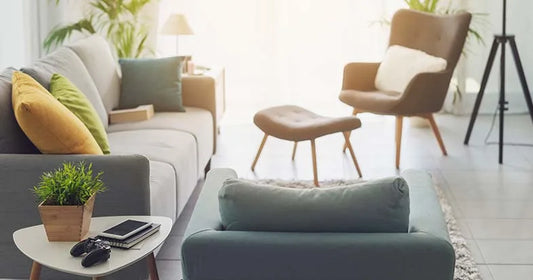 A stylishly curated living room featuring a grey sofa, mustard yellow cushions, and modern accent chairs.