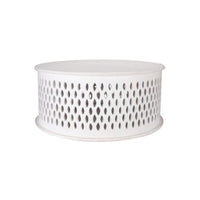 Round coffee table with natural textures and crafted details, displayed in a stylish contemporary lounge.