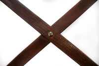 Durable timber dining chair with cross back design, displayed in a high-traffic dining area.