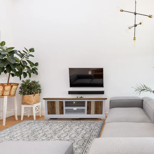 Vibrant acacia sideboard with unique design and metal handles, set in a colorful living room.